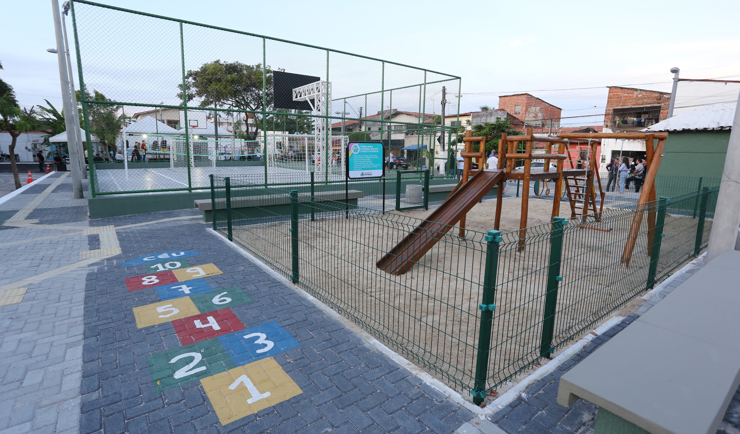 praça com parquinho e quadra de esportes